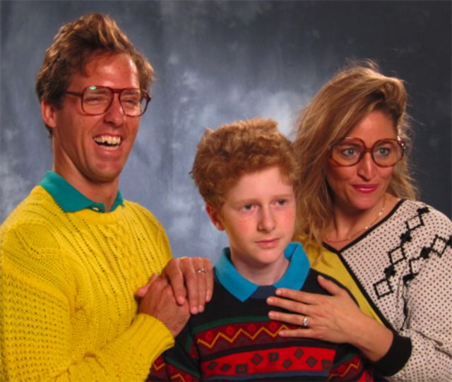 Retro 1980s family portrait of a dad, mum and son in bright sweaters